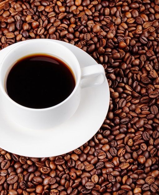 Top view of a cup of coffee on coffee beans