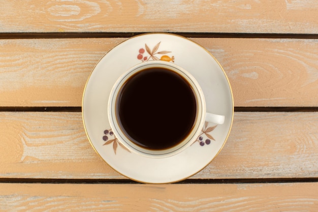 Foto gratuita una tazza di caffè con vista dall'alto calda e forte sul tavolo rustico color crema bere una foto di caffè forte