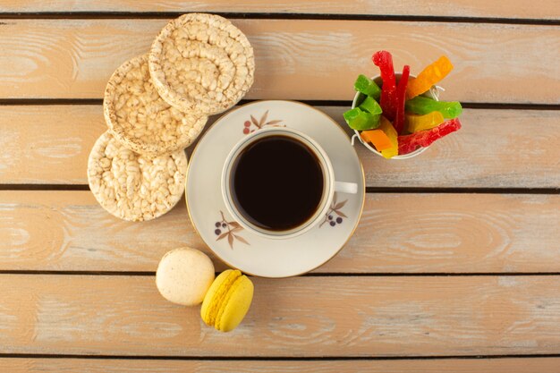 A top view cup of coffee hot and strong with french macarons and marmalade on the cream colored rustic desk drink coffee photo strong biscuit