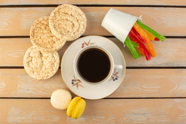 A top view cup of coffee hot and strong with french macarons and marmalade on the cream colored rustic table drink coffee photo strong