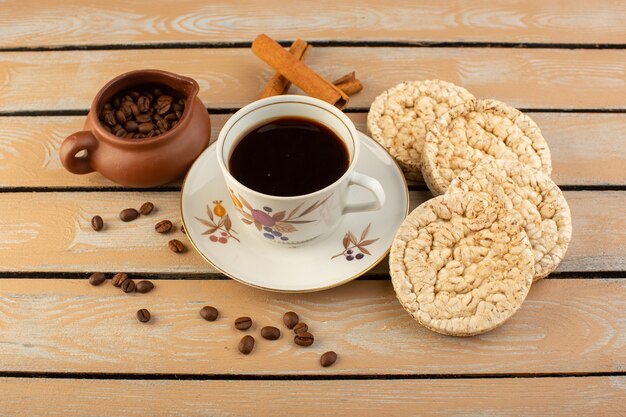 A top view cup of coffee hot and strong with fresh brown coffee seeds and crackers on the cream rustic desk coffee seed drink photo grain