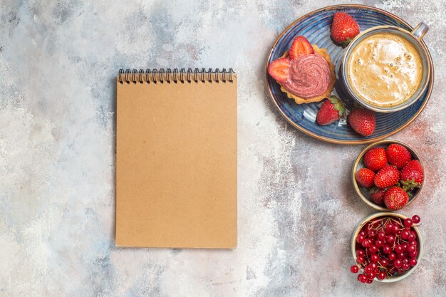 Top view cup of coffee with cake and red fruits on light floor sweet biscuit cake