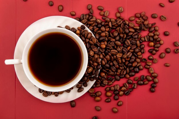 Top view of a cup of coffee with coffee beans isolated on a res background