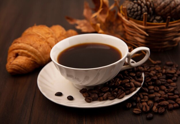 Top view of a cup of coffee with coffee beans isolated on a wooden surface