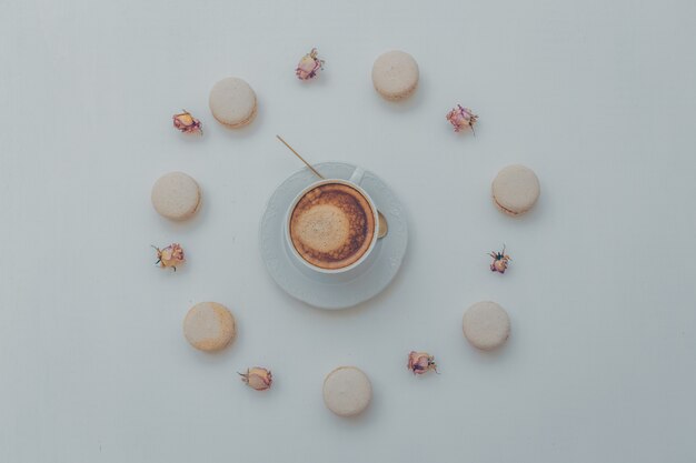 Вид сверху на чашку кофе с печеньем и декоративными элементами на белом