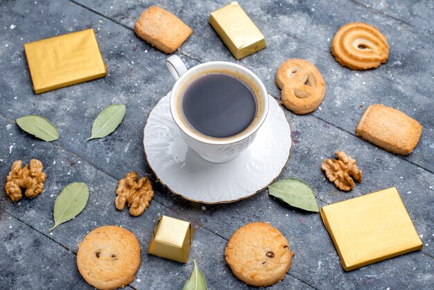 灰色の机の上にクッキークルミ、クッキービスケット甘い一杯のコーヒーの上面図