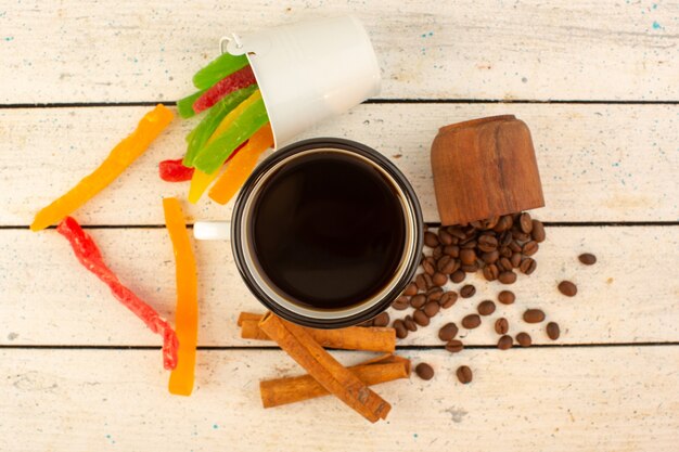 A top view cup of coffee with fresh brown coffee seeds and colorful marmalade