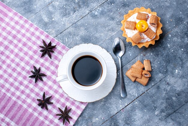 明るいコーヒークッキービスケットの甘い生地に枕形のビスケットとクリーミーなケーキとコーヒーのカップの上面図