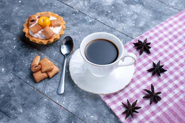 Top view of cup of coffee with pillow formed biscuits and creamy cake on bright, coffee cookies biscuit sweet dough