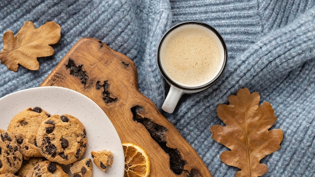 Free photo top view of cup of coffee with sweater and autumn leaves