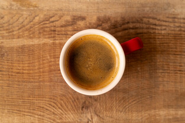 Вид сверху чашка кофе с деревянным фоном