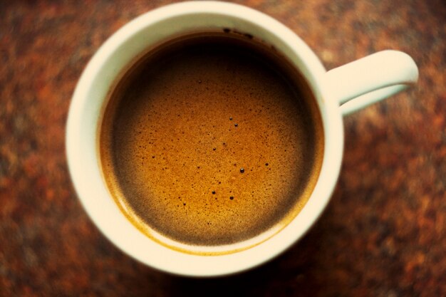 Top view of a cup of coffee on a wooden table