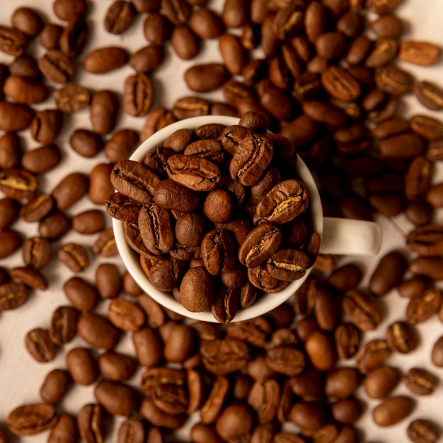 Vista dall'alto tazza piena di chicchi di caffè tostati