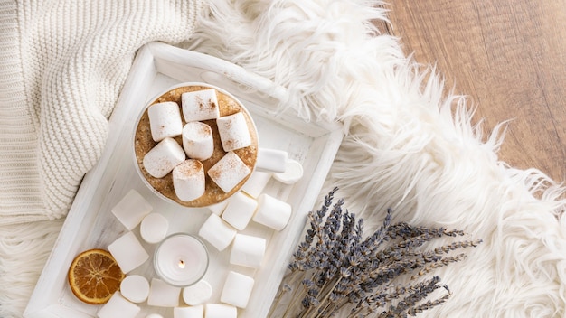 Top view of cup of marshmallows on tray with lavender and dried citrus
