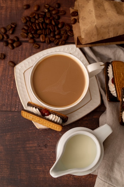 Top view cup of milk coffee with sweets 