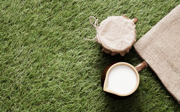 Top view cup of milk on grass with copy space