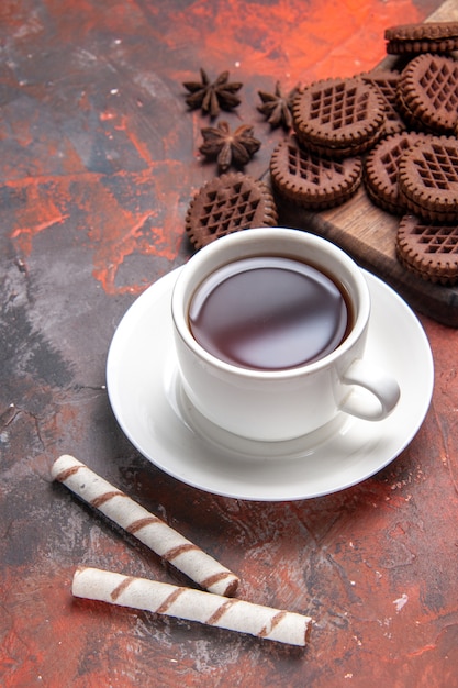 Бесплатное фото Вид сверху чашка чая с шоколадным печеньем на темном столе, печенье с чаем