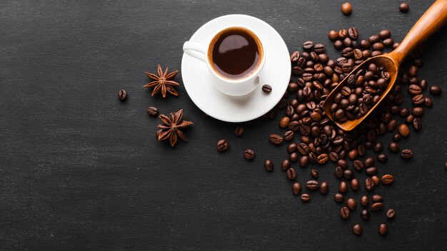 Top view cup surrounded by coffee beans