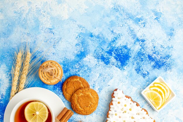 Top view cup of tea biscuits on blue table