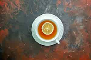 Free photo top view cup of tea flavored by lemon on dark red ground with ree space