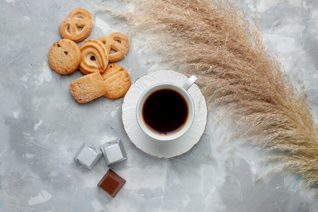 Вид сверху на чашку горячего чая с шоколадом и печеньем на свете, печенье, конфеты, шоколадное чайное печенье