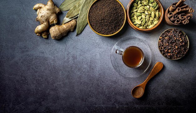 Top view of a cup of tea and Indian seasonings on a table