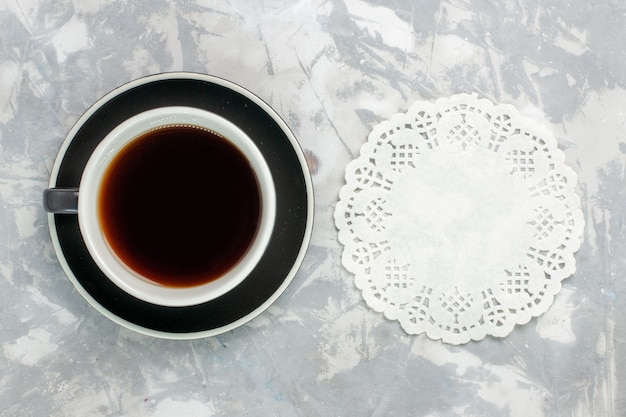 Вид сверху чашка чая внутри чашки и тарелки на светлой белой поверхности