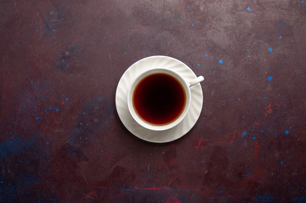 Вид сверху чашка чая внутри тарелки и чашка на темном фоне чайный напиток цветное фото сладкое