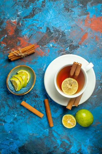 Top view a cup of tea lemon slices on blue red surface copy place