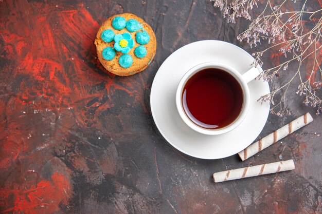 Top view cup of tea with biscuits on dark table