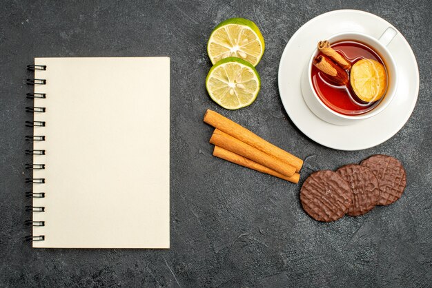 Top view cup of tea with biscuits and lemon slices