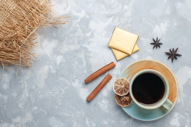 Vista dall'alto tazza di tè con caramelle e cannella sulla colazione colore caramella tè scrivania leggera