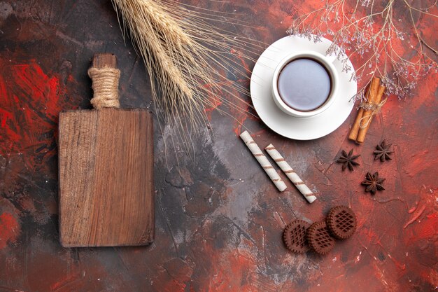暗い床のティークッキービスケットにチョコクッキーとお茶のトップビューカップ