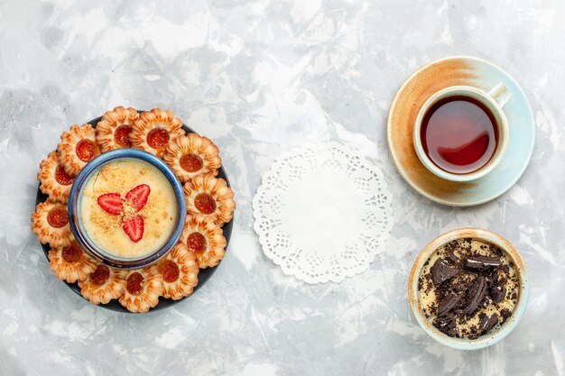 Top view cup of tea with chocolate cookie dessert and jam cookies on light-white desk cookie chocolate cake bake pie sugar sweet