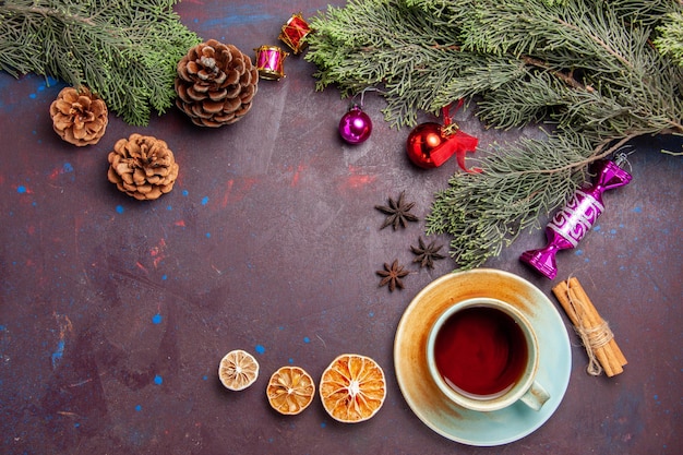 Top view cup of tea with christmas tree on dark space