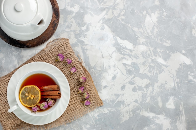 Top view cup of tea with cinnamon and lemon on the light-white surface