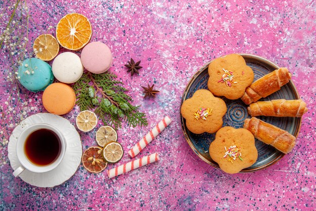 핑크 벽 케이크 비스킷 설탕 달콤한 파이 차 쿠키에 화려한 프랑스 마카롱과 베이글과 차의 상위 뷰 컵