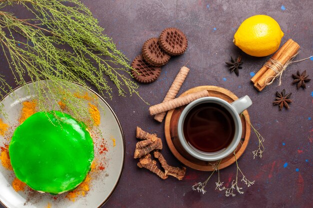 Top view cup of tea with cookies cake and lemon on dark surface tea sweet color photo