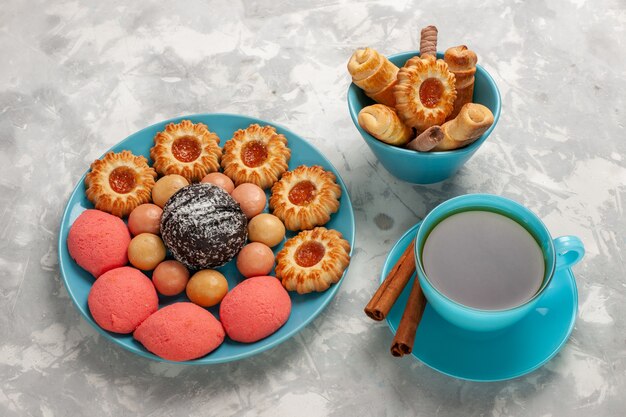 Top view cup of tea with cookies and cakes on white surface