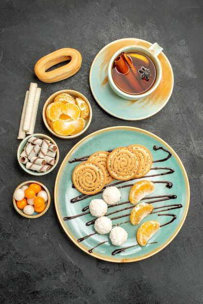 Top view cup of tea with cookies and candies on grey table cookie cake biscuit tea