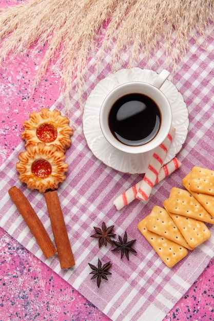 ピンクの机の上のクッキーとクラッカーとお茶のトップビューカップクッキービスケットシュガー甘いクリスプ