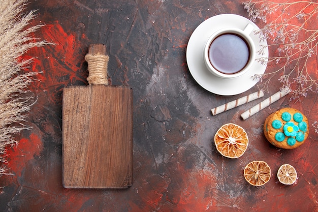 Free photo top view cup of tea with cookies on dark table