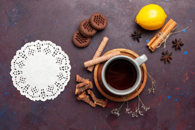 Top view cup of tea with cookies and lemon on dark background tea sweet color photo