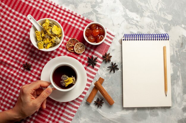 Top view cup of tea with dessert and different jams on the white desk fruit jam tea sweet sugar