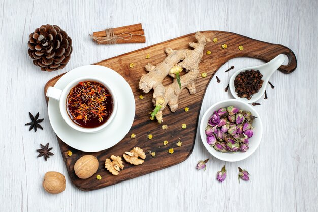 Top view cup of tea with dried flowers and walnuts on white background tea drink nut