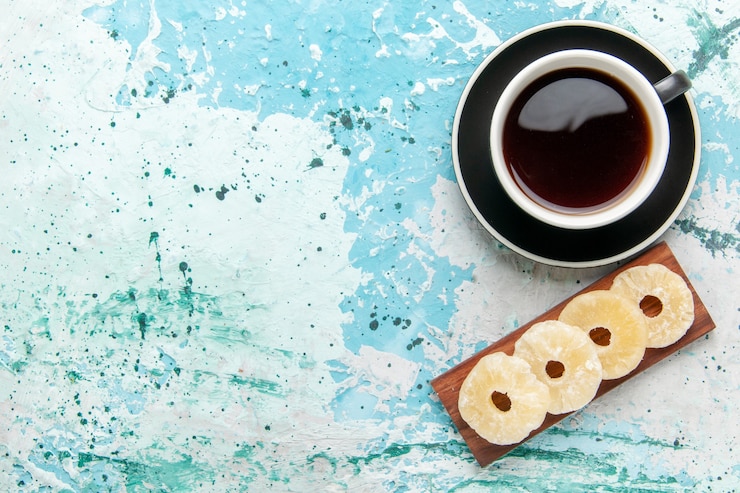 मुफ़्त फोटो top view cup of tea with dried pineapple rings on blue surface