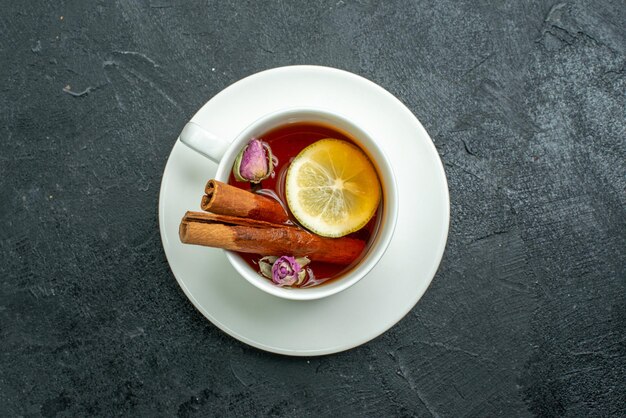 Top view cup of tea with flowers and tea on dark surface tea fruit citrus ceremony