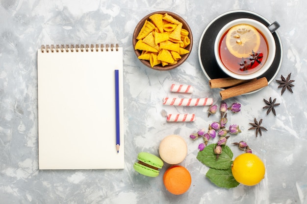 Top view cup of tea with french macarons on light-white desk