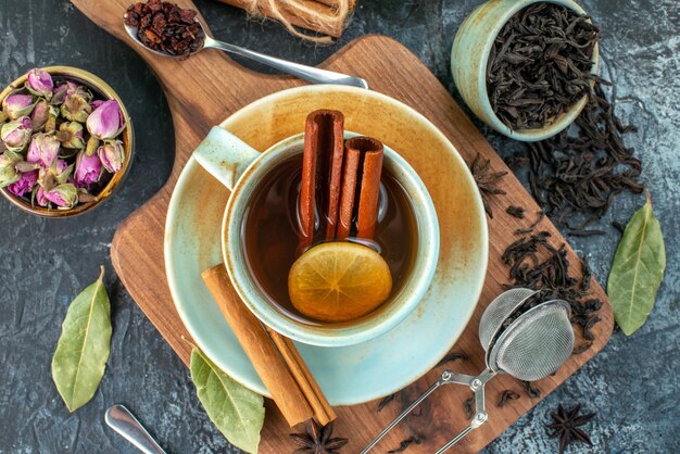 Top view cup of tea with fresh black tea and flowers on gray background flower color flavor tea ceremony breakfast photo coffee