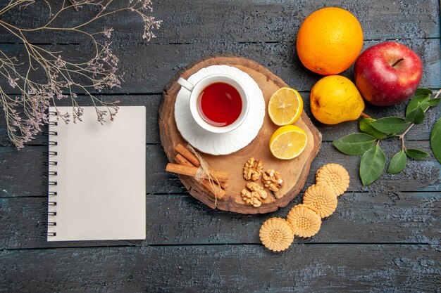 Top view cup of tea with fruits and cookies, sweet biscuit sugar